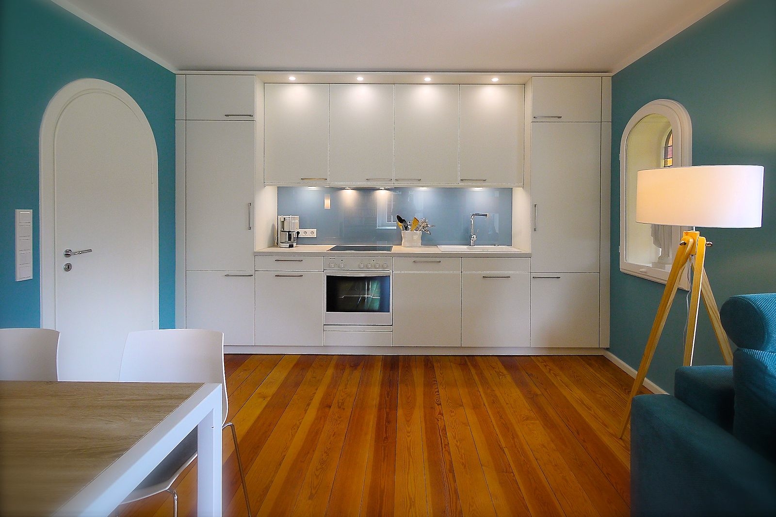 Moderne Einbauküche in zeitlosem Weiß im Wohnraum integriert