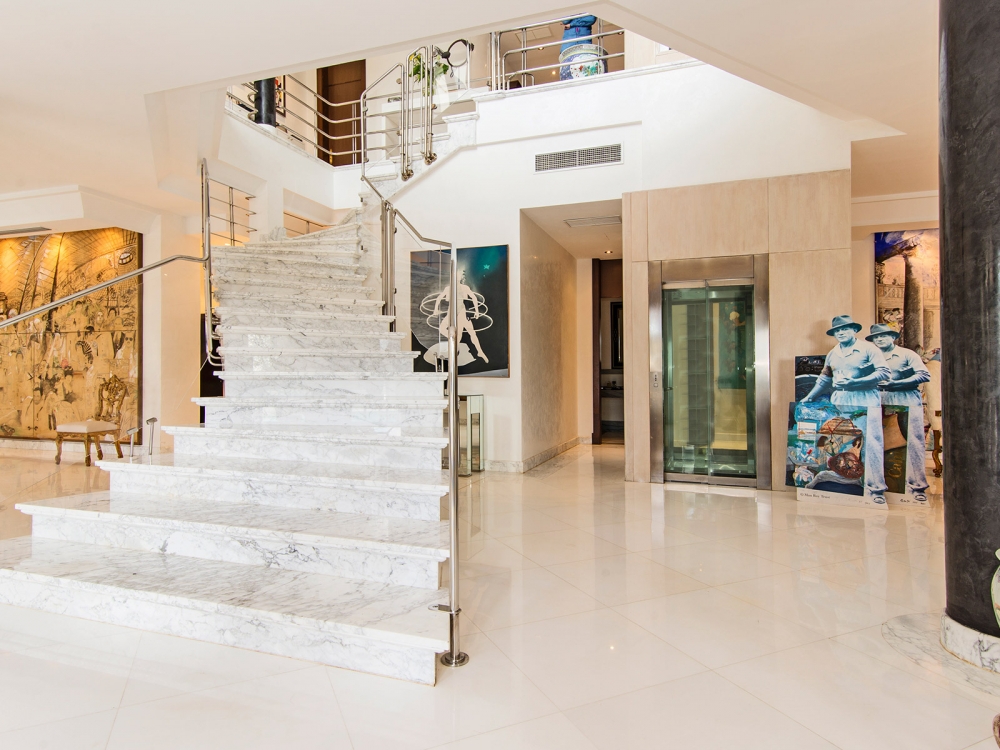 Elegante Treppe sowie Fahrstuhl zum Obergeschoss